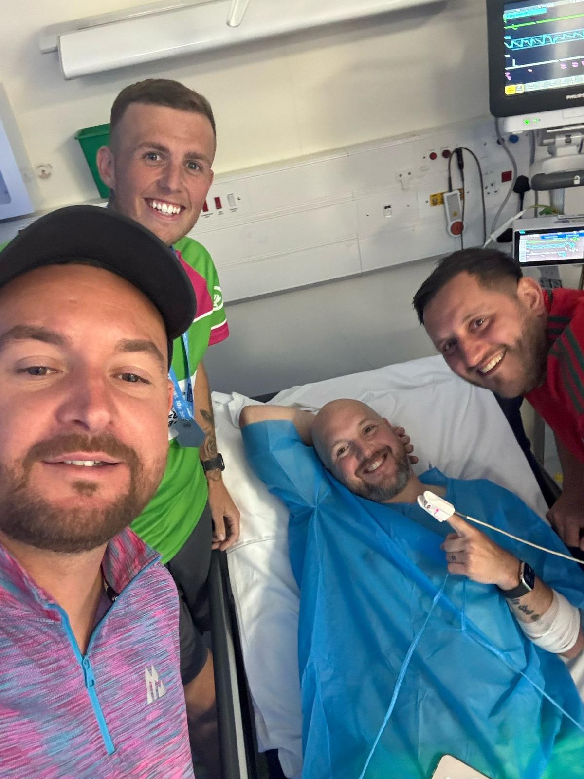 Image credit: Chris Edwards, who is pictured in the centre lying in a hospital bed